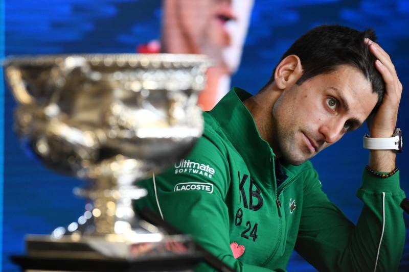 Serbia\'s Novak Djokovic sits beside the Norman Brookes Challenge Cup trophy during a press conference after beating Austria\'s Dominic Thiem in Australian Open final in Melbourne