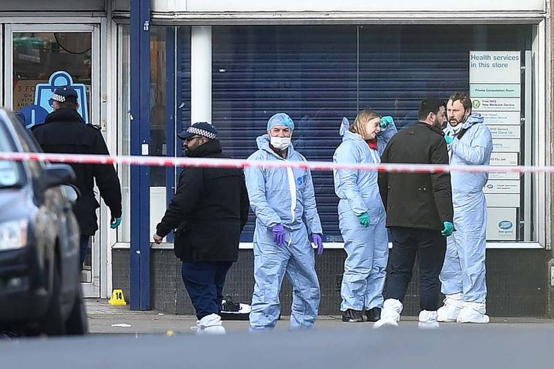 Police forensic officers work outside of a Boots store on Streatham High Road in south London