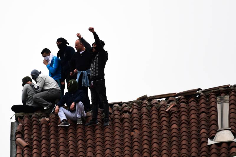 Convicts on roof, fatalities as Italy jails protest virus