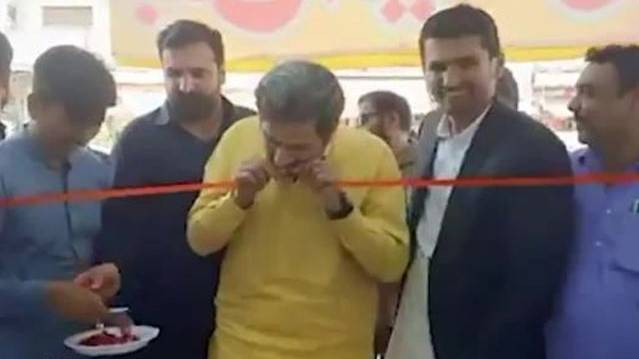 Fayyaz Chohan uses teeth to cut ribbon 