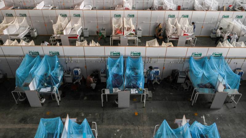 Patients take rest on beds arranged inside a makeshift dengue ward in a hospital in Lahore. AFP