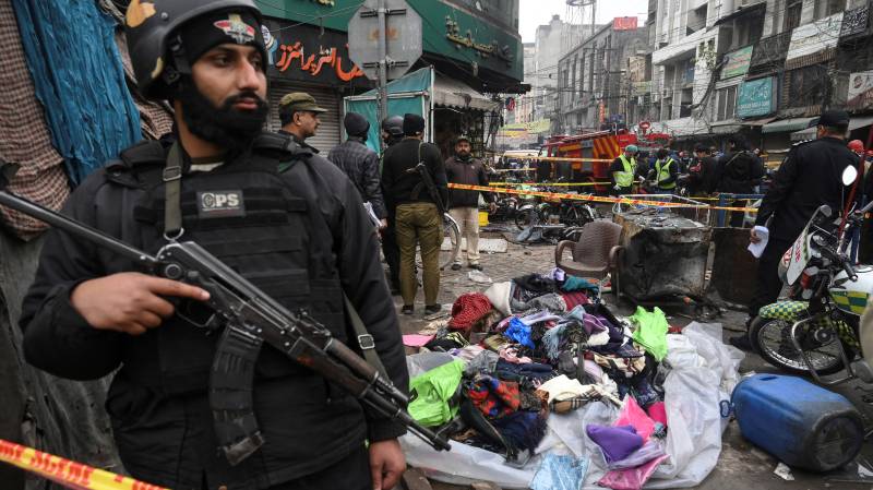 Security officials inspect the site of a bomb blast that killed two people and wounded 22 others at a busy shopping district in Lahore. AFP