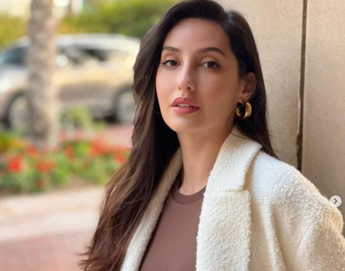 Anonymous man observes Nora Fatehi as she poses for casual daytime clicks 