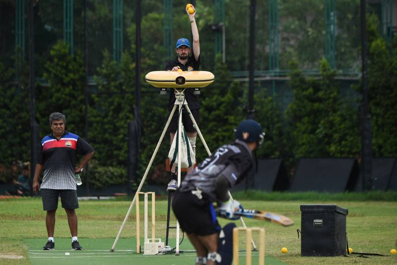 Evan McCall (back R), a trainer for the Philippines national cricket team, operates a ball machine during a team training session at the United Club pitch in Paranque City in suburban Manila. AFP