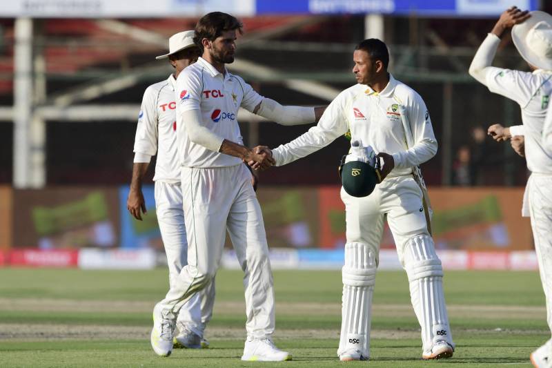 Pakistan's Shaheen Shah Afridi (L) shakes hands with Australia's Usman Khawaja at the end of the first day play of the second Test cricket match between Pakistan and Australia at the National Cricket Stadium in Karachi. AFP