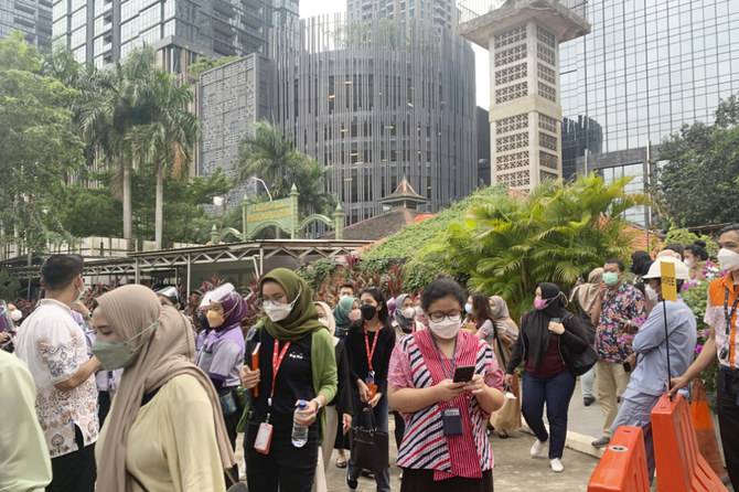 People wait outside as they have to evacuate their office buildings following an earthquake, at the main business district in Jakarta, Indonesia. 