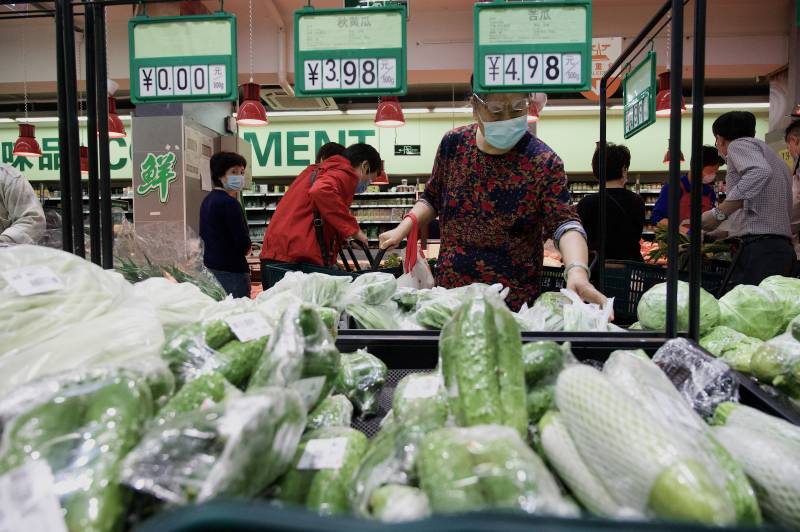 People buy food and household provisions at a supermarket in Beijing. AFP