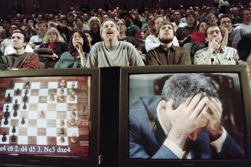 In this file photo taken on May 11, 1997 Chess enthusiasts watch World Chess champion Garry Kasparov on a television monitor as he holds his head in his hands at the start of the sixth and final match May 11, 1997 against IBM's Deep Blue computer in New York. AFP