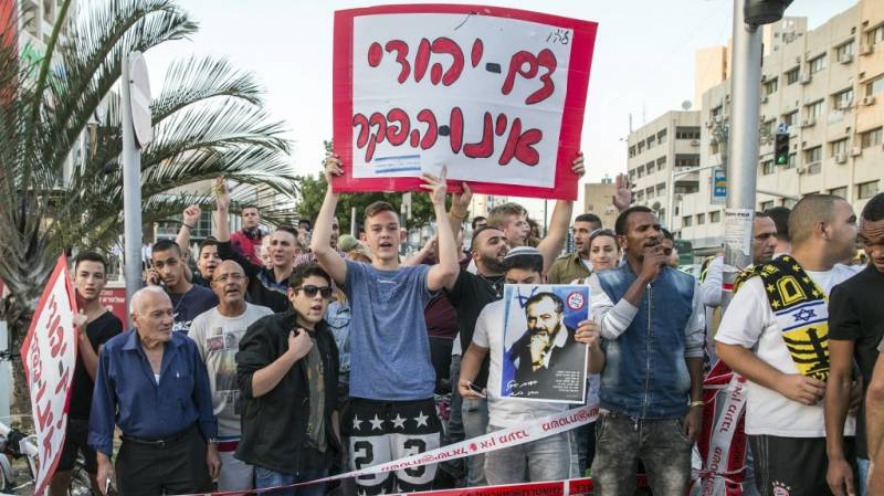 Israeli far-right demonstrators hold a placard that reads in Hebrew 