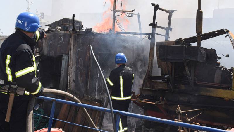 A handout image made available by the Odessa City Council Telegram channel shows Ukrainian firefighters battling a fire on a boat burning in the port of Odessa after missiles hit the port. AFP