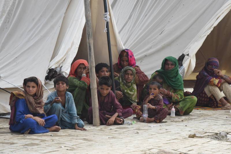 Flood-affected people sit in a tent at a makeshift camp after heavy monsoon rains in Jaffarabad district, Balochistan province. AFP