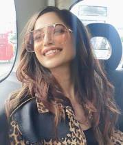 Aima Baig shared pictures showing her seated in the backseat of a car wearing a three-piece suit with an animal design and a pair of shades