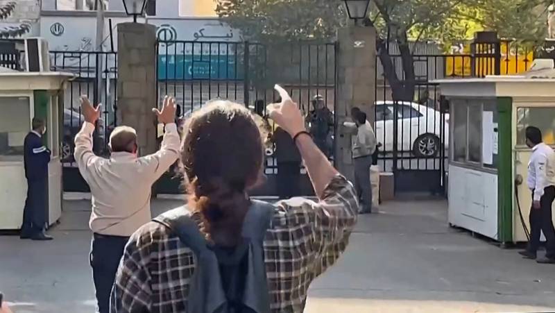 Iranian students at Tehran University shouting at Iranian security forces gathered outside the gate of their campus. AFP