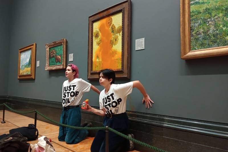 A handout picture from the Just Stop Oil climate campaign group shows activists with their hands glued to the wall under Vincent van Gogh's 