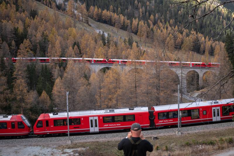 A member of the public captures images as a 1910-metre-long train with 100 cars passes near Bergun, during a record attempt by the Rhaetian Railway (RhB) of the World's longest passenger train, to mark the Swiss railway operator's 175th anniversary. AFP