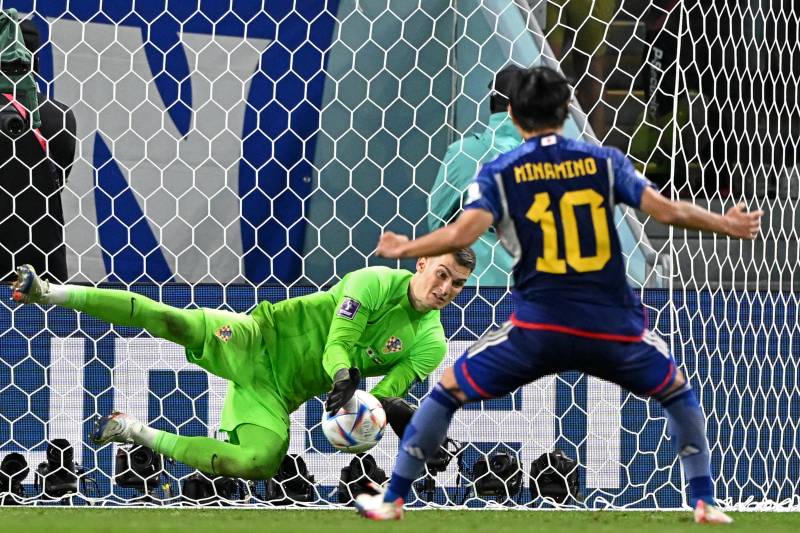 Croatia's goalkeeper Dominik Livakovic (L) saves the penalty of Japan's midfielder Takumi Minamino during the Qatar 2022 World Cup round of 16 football match between Japan and Croatia. AFP