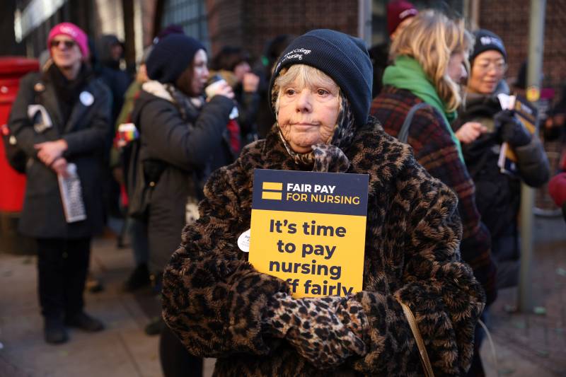 A supporter of nurses' strike and NHS holds a placard at a picket line outside St Mary's Hospital in west London. AFP