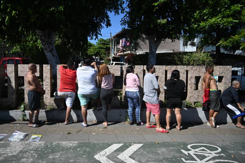 Alleged members of the Calle 18 gang and drug dealers captured by soldiers and police are seen at the Tutunichapa community in San Salvador, on December 24, 2022. More than 1,000 soldiers surrounded Tutunichapa community on December 24, 2022, as part of President Nayib Bukele's war on gangs, in the second such operation this month in the Central American country. AFP