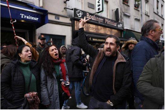 People shout slogans following a shooting along rue d'Enghien in the 10th arrondissement, in Paris on December 23, 2022. AFP 