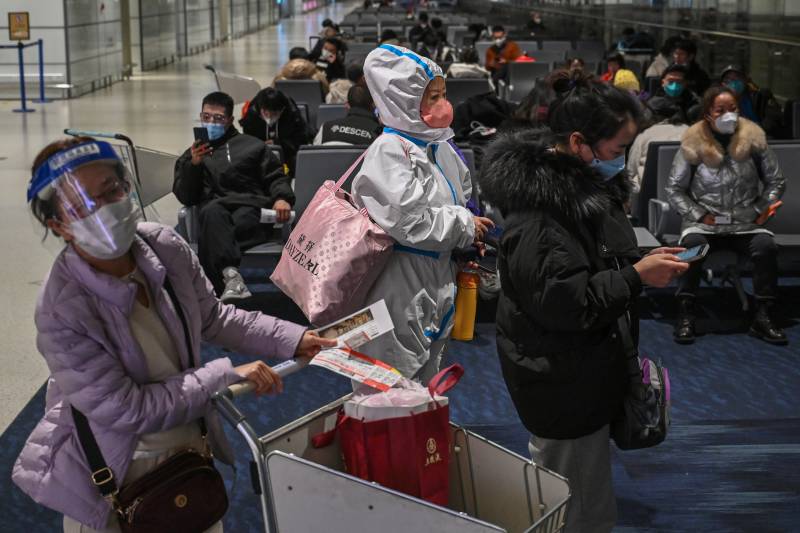 A passenger wearing protective clothing amid the Covid-19 pandemic waits to board a domestic flight at Shanghai Pudong International Airport in Shanghai. AFP