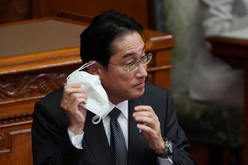 Japanese Prime Minister Fumio Kishida removes his face mask before his speech during a plenary session of the upper house of parliament in Tokyo. AFP