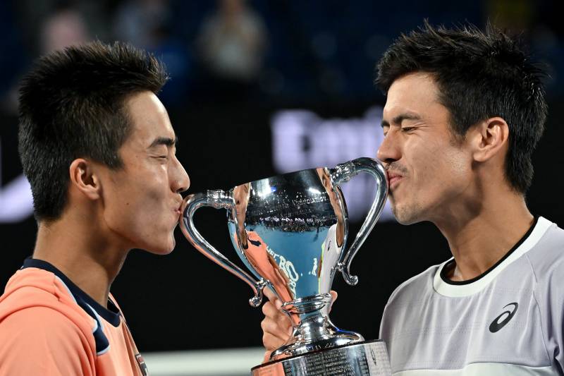 Australia's Rinky Hijikata (L) and Jason Kubler pose with the trophy after victory against Poland's Jan Zielinski and Monaco's Hugo Nys during the men's doubles final on day thirteen of the Australian Open tennis tournament in Melbourne. AFP