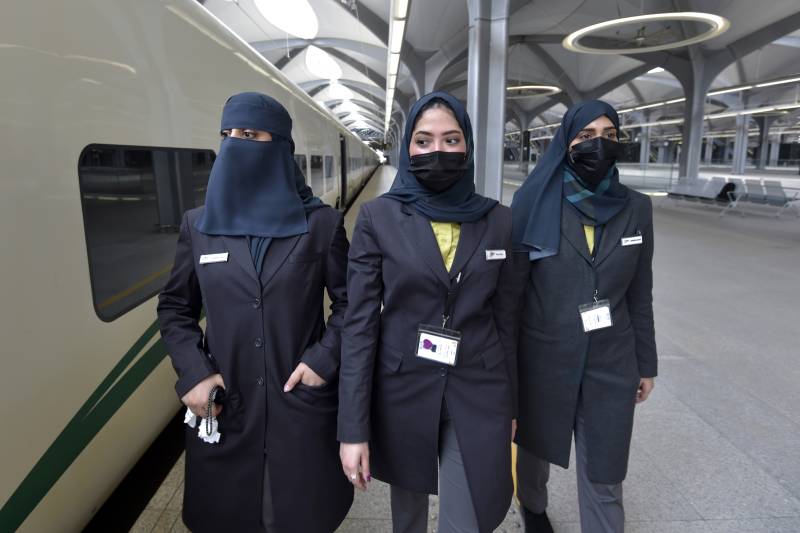 Saudi conductors walk beside a high-speed train ferrying pilgrims to Mecca, in Saudi Arabia's Red Sea coastal city of Jeddah. AFP 