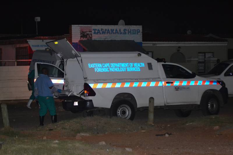 Members of the Forensic Pathology Services stand near their vehicles on the scene of a mass shooting in Gqeberha, South Africa. AFP