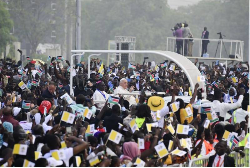 Pope Francis (C) waves as he arrives by popemobile for the holy mass at the John Garang Mausoleum in Juba, South Sudan, on February 5, 2023. AFP 