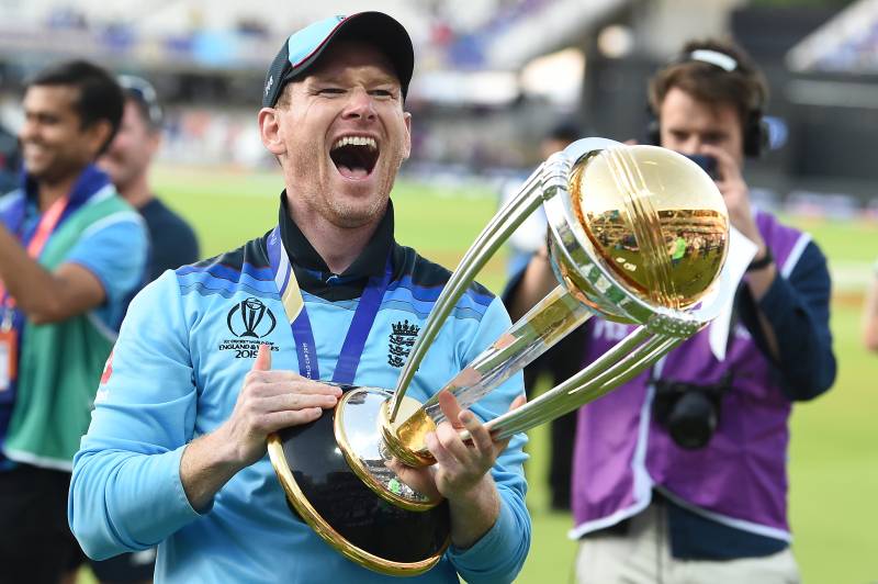 In this file photo taken on July 14, 2019 England's captain Eoin Morgan celebrates with the World Cup trophy on the pitch after the 2019 Cricket World Cup final between England and New Zealand at Lord's Cricket Ground in London. AFP