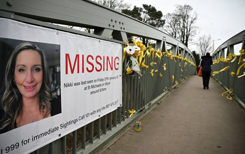 Daffodils and yellow ribbons are pictured tied to a bridge crossing the River Wyre, alongside a poster for missing Nicola 'Nikki' Bulley, in St Michael's on Wyre, near Preston, north west England. AFP