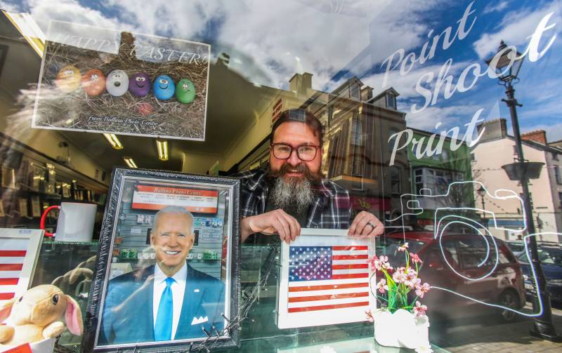 Derek Furlong poses in the window of his Ballina photo centre, as he and others dress up their business properties in Ballina town centre on April 7, 2023 as the town prepares to welcome President Biden to the town in Co Mayo, the his ancestral home. AFP