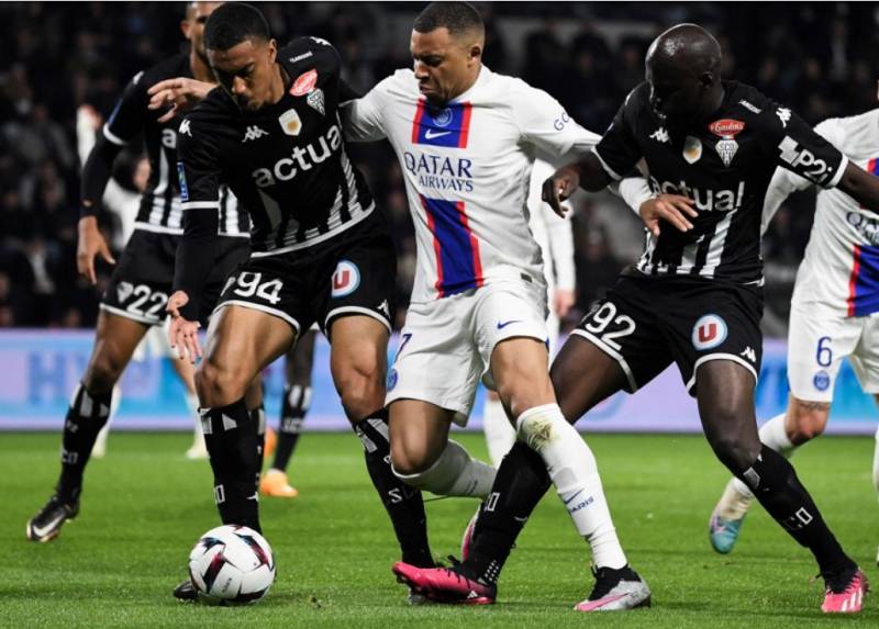 Kylian Mbappe (C) fights for the ball with Angers' players. AFP