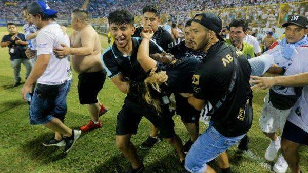 An injured fan is carried to the field of Cuscatlan stadium in San Salvador.