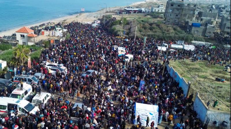 Displaced Gazans mass at Israeli barrier waiting to reach north